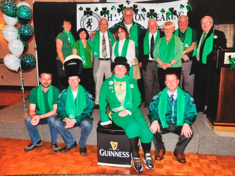 Group shot of wearing of the green committee on stage at ceremony.